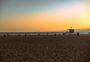los angeles beach at sunset with lifeguard booth in california.