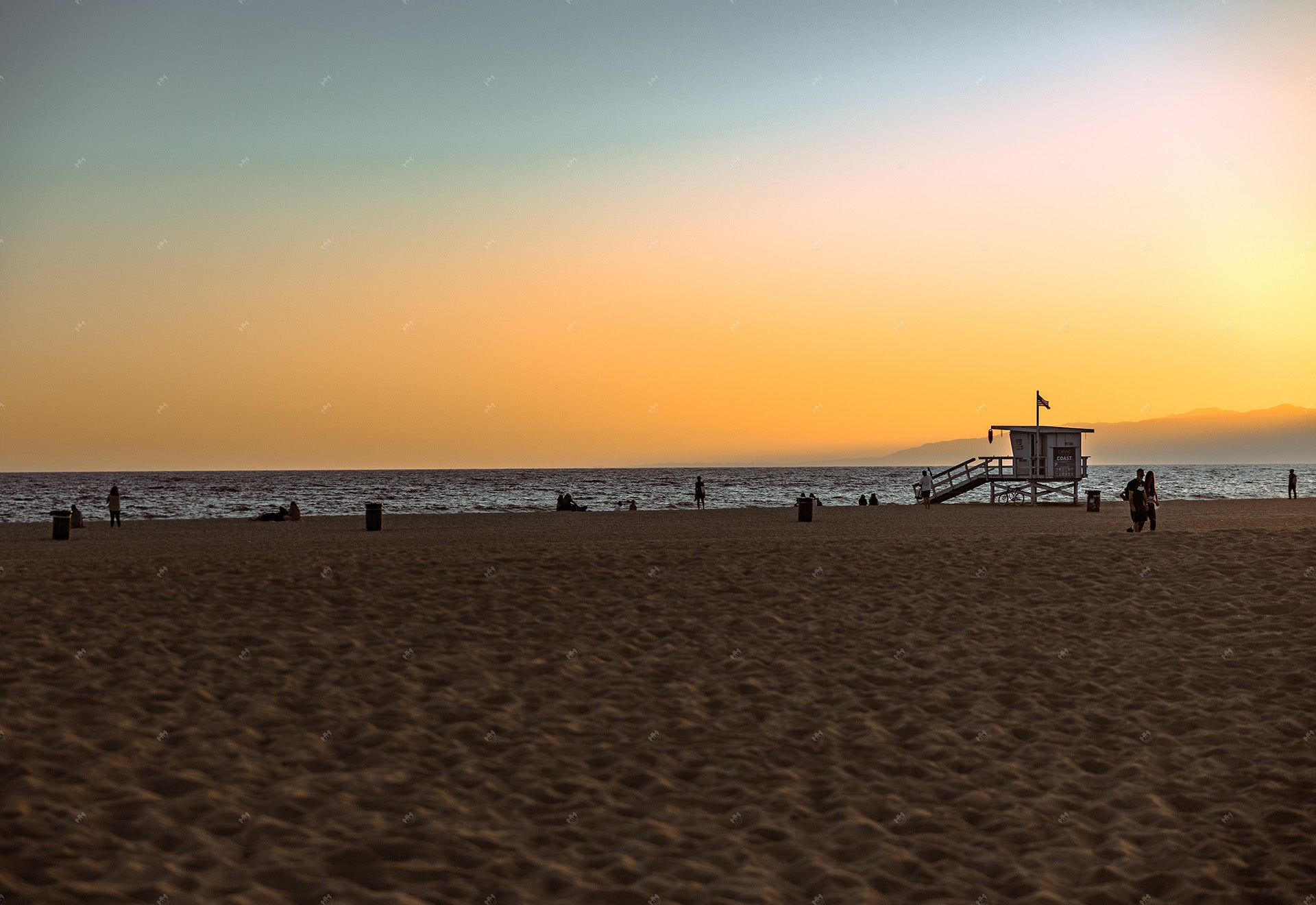 los angeles beach at sunset with lifeguard booth in california.