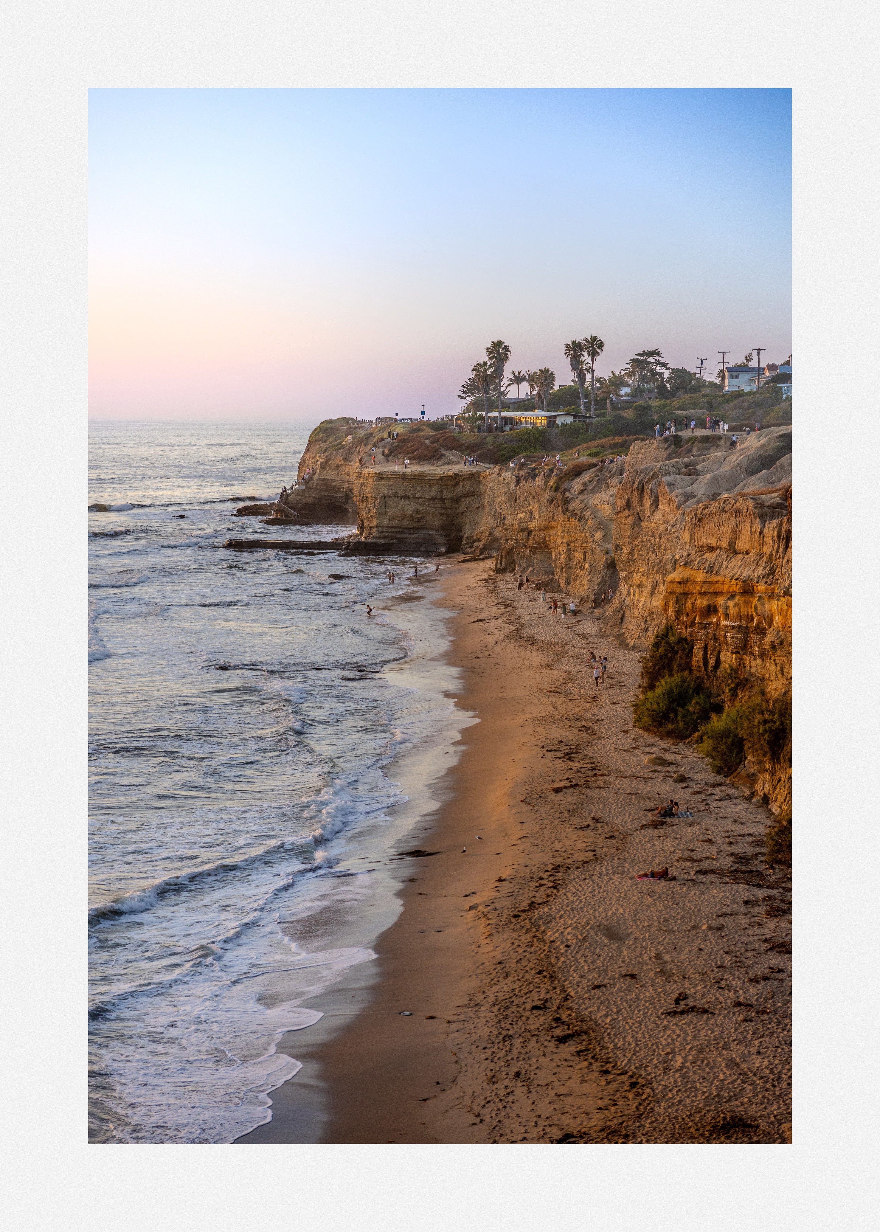 Discover romantic beach art print of rocky cliffs under a golden sunset.