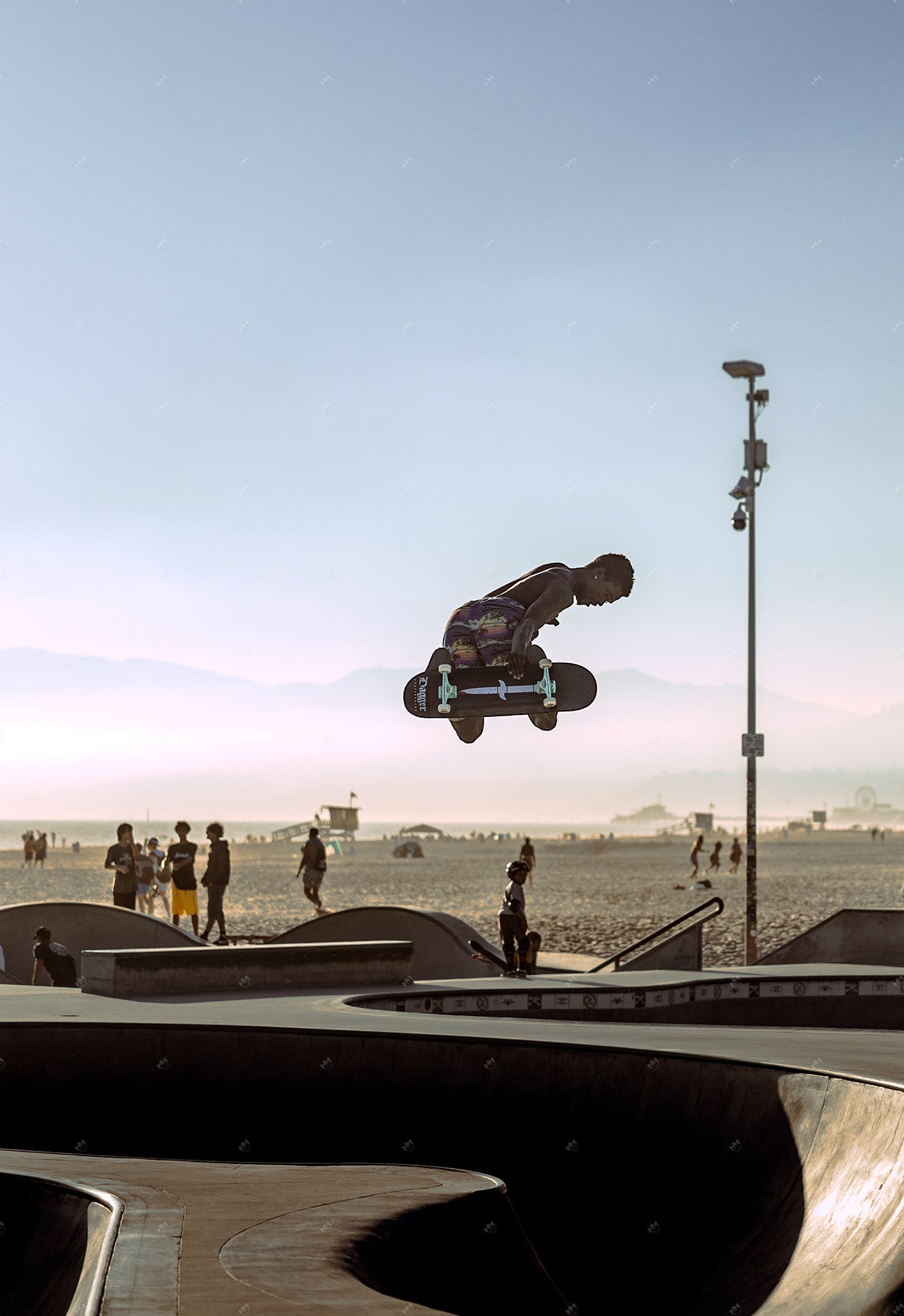 skater doing jumps in front of the beach at skatepark.